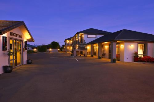 a row of buildings with lights in a parking lot at Oamaru Motor Lodge in Oamaru