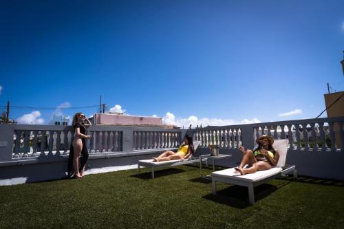 three women sitting on chairs on a balcony at Navona Studios in San Juan