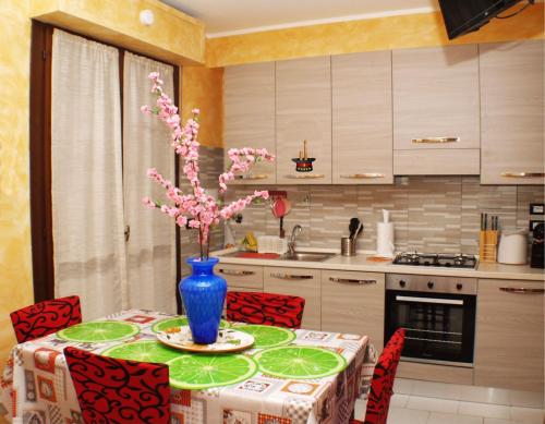 a kitchen with a table with a vase of flowers on it at Magica Bologna in Bologna