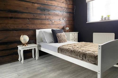 um quarto com uma cama e uma parede de madeira em Seaview House em Aberdeen