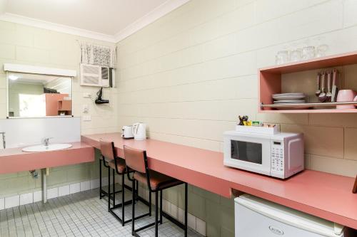 a kitchen with a microwave and a counter top at Yungaburra Park Motel in Yungaburra