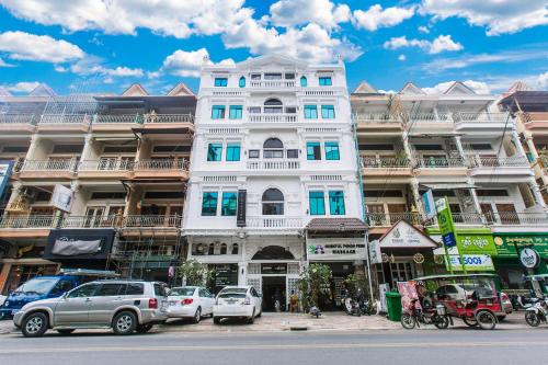a white building with cars parked in front of it at Grand Elevation Hotel in Phnom Penh