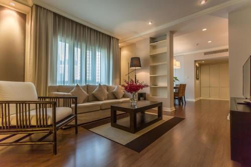 a living room with a couch and a table at At 21 Saladaeng in Bangkok