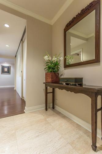 a hallway with a mirror and a table with a plant at At 21 Saladaeng in Bangkok
