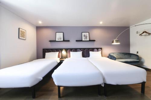 two beds in a room with purple walls at Hotel Hyggelig in Busan