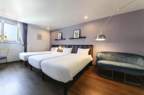 a hotel room with two beds and a couch at Hotel Hyggelig in Busan