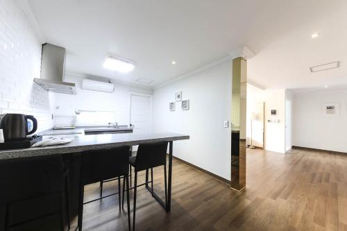 a kitchen with a counter and chairs in a room at Hotel Hyggelig in Busan