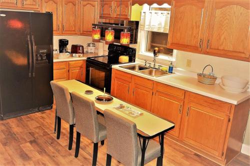a kitchen with a table and a black refrigerator at The Bungalow in Grand Forks