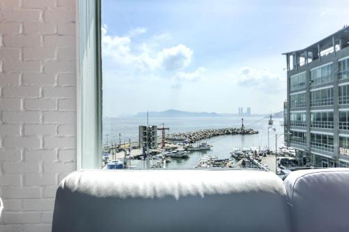 a window with a view of a harbor with boats at Hotel Hyggelig in Busan