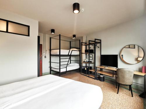 a bedroom with a bed and a desk and bunk beds at W22 by Burasari in Bangkok