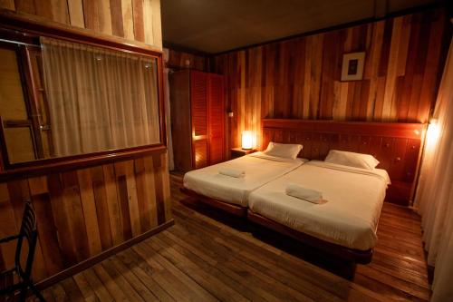 a bedroom with a bed with two towels on it at Joe Fisherman Inn in Pangkor
