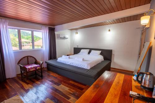 a bedroom with a bed and a chair and a window at Joe Fisherman Inn in Pangkor
