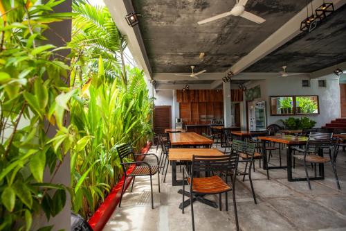 a restaurant with wooden tables and chairs and plants at Joe Fisherman Inn in Pangkor