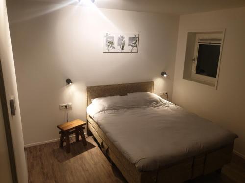 a small bedroom with a bed and a table at De Dierenweiden in Goedereede