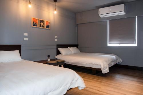 a bedroom with two beds and a window at EasyLiving in Tainan