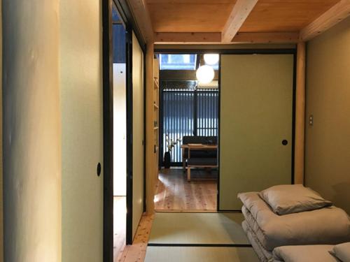 a room with two beds and a room with a hallway at Kikuhama in Kyoto