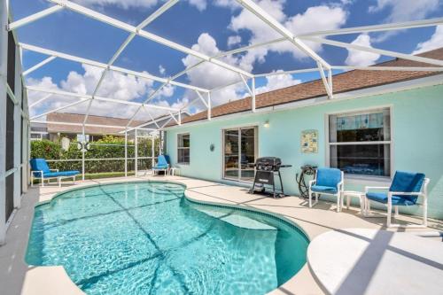 a swimming pool with blue chairs and a house at 1566 Oak Hill Trail Villa #105715 Villa in Orlando