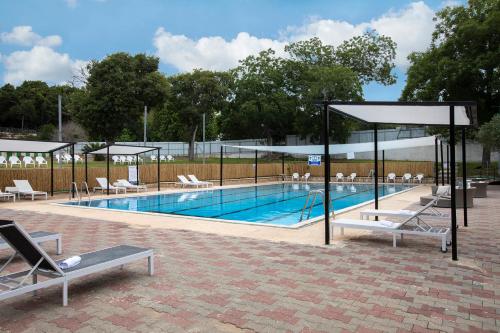a swimming pool with lounge chairs and aophe at Eden Inn in Zikhron Ya'akov