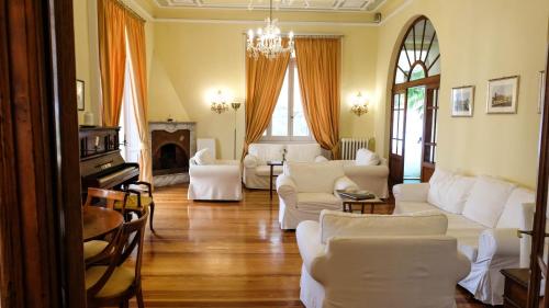 una sala de estar con muebles blancos y una lámpara de araña. en Hotel Canali, Portofino Coast, en Rapallo