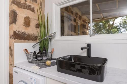 a kitchen counter with a black sink and a window at The Chapel in Lyndoch