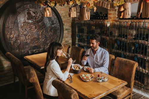 a man and woman sitting at a table drinking wine at Ortner's Resort in Bad Füssing