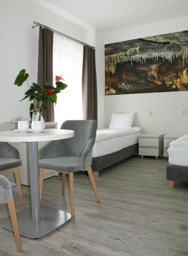 a hotel room with a bed and a table and chairs at Hotel Stronie in Stronie Śląskie