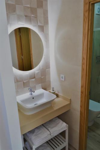 ein Badezimmer mit Waschbecken und Spiegel in der Unterkunft CASA SOLORGA - apartamentos rurales in San Miguel de Meruelo