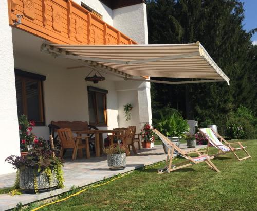 a patio with chairs and a wooden umbrella at Haus Wassermann in Kleblach