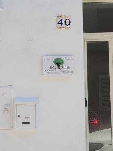 a sign on a wall next to a door at S'Ilixi in Quartucciu