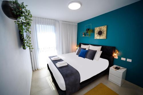 A bed or beds in a room at YalaRent Migdalor Boutique Hotel Apartments with Sea Views Tiberias