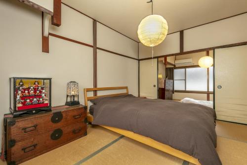 1 dormitorio con cama y vestidor con TV en Koyasu - Traditional house near Silver Pavilion en Kioto