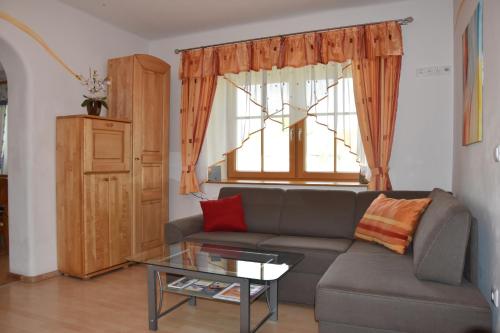 een woonkamer met een bank en een glazen tafel bij Biohof Weissensteiner in Ullrichs