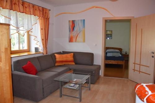 ein Wohnzimmer mit einem Sofa und einem Tisch in der Unterkunft Biohof Weissensteiner in Ullrichs