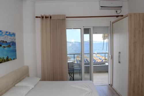 a bedroom with a bed and a view of the ocean at Zero Zero Apartments Sarande in Sarandë