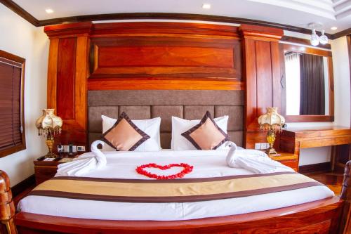 a bedroom with a large bed with a red heart on it at Kampong Thom Palace Hotel in Kompong Thom