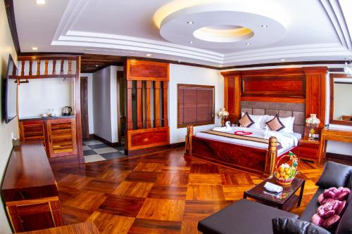 Kampong Thom Palace Hotel في كومبونغ ثوم: غرفة نوم مع سرير وغرفة معيشة