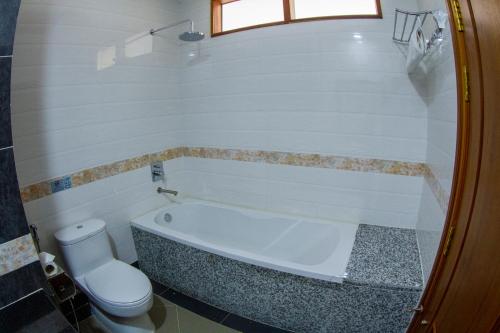 a bathroom with a bath tub and a toilet at Kampong Thom Palace Hotel in Kompong Thom