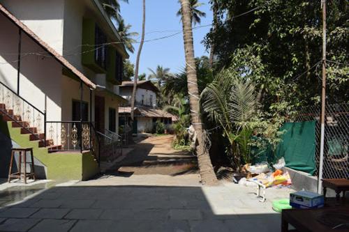 eine Person, die auf dem Boden neben einem Gebäude sitzt in der Unterkunft Smita Villa in Alibag