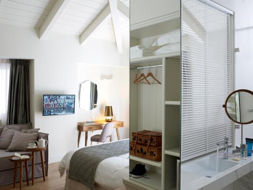 a bedroom with a bed and a desk and a mirror at Marpessa Hotel & Spa in Agrinion