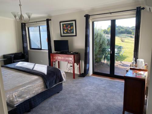 1 dormitorio con cama, escritorio y ventana en Harmony Bed & Breakfast, en Fingal