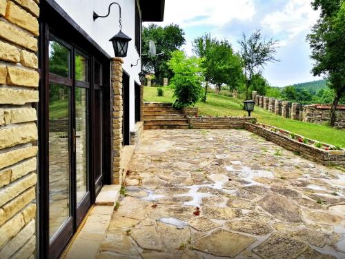 a stone patio with a stone walkway next to a building at Бор и Шишарка in Varzilkovtsi