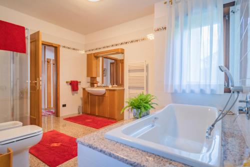 a bathroom with a tub and a toilet and a sink at B&B Nonno Carlo in Trento