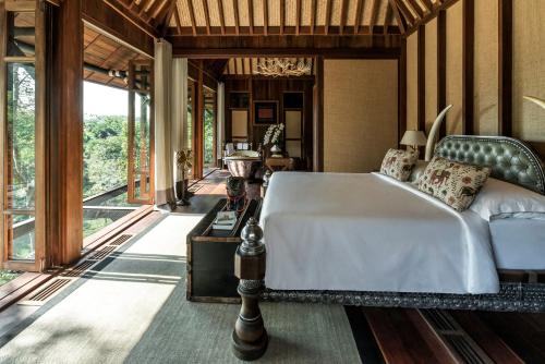 um quarto com uma cama e uma grande janela em Four Seasons Tented Camp Golden Triangle em Golden Triangle