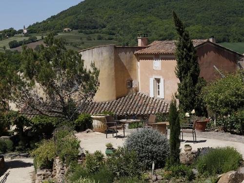 a house with a table and chairs in a garden at La Palombe in Octon