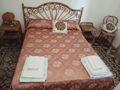 un letto con piumone rosso e asciugamani di Musica e poesia da Battisti Ida a Poggio Bustone