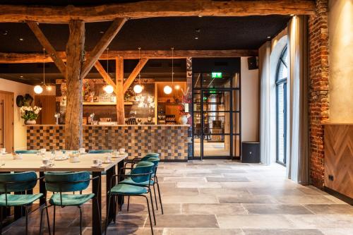 a dining room with tables and chairs and a bar at Graaf ter Horst in Horst