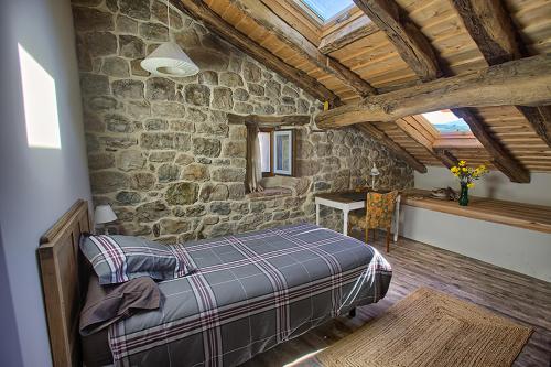 a bedroom with a bed and a stone wall at La Curva De María in Terán