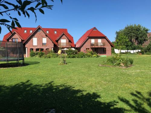 eine Gruppe von Häusern auf einem Grasland in der Unterkunft Hillrichshof in Neuharlingersiel