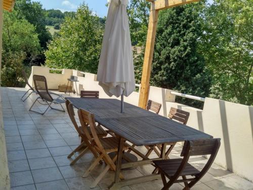 - une table en bois avec un parasol sur la terrasse dans l'établissement Domaine De La Petite Tour, à Montréal