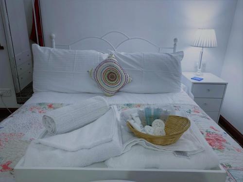 a bed with towels and a basket on it at Pew with a View - Seafront Cottages in Sandhaven